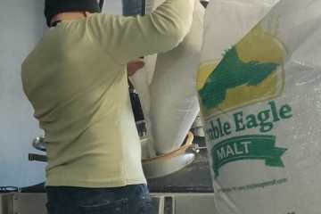 Picture of a man adding malt in machinery