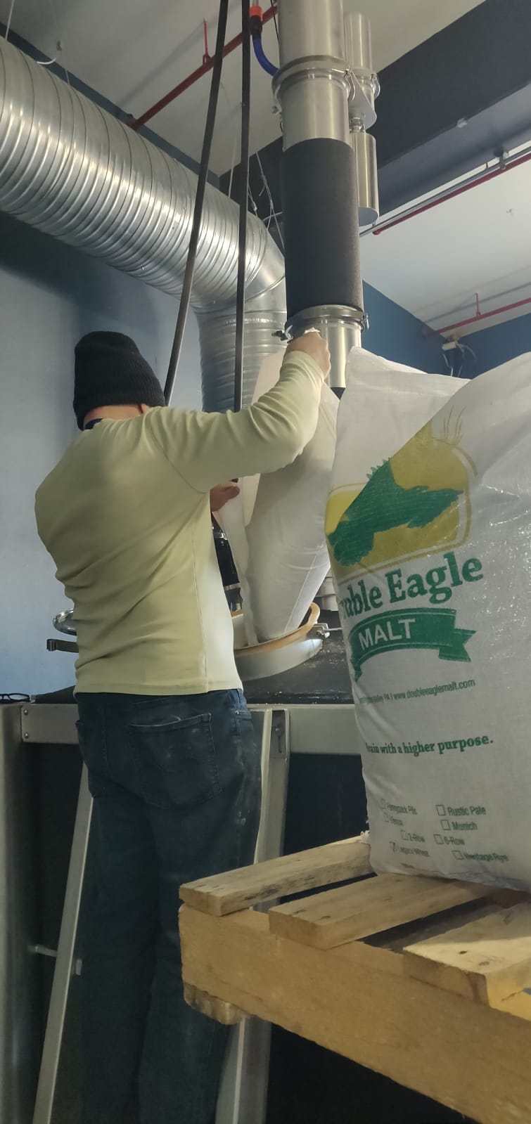 Picture of a man adding malt in machinery